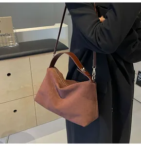 Détails du sac bandoulière en daim marron avec lanières en cuir et garniture argentée