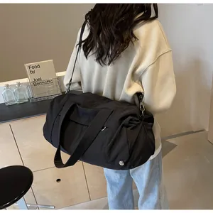 Dettaglio borsa da viaggio in nylon nero impermeabile con tracolla regolabile e grande manico