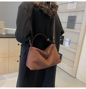 Vue détaillée d'un sac hobo en daim marron avec boucles en métal doré