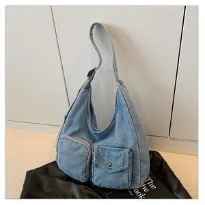 Détails du sac hobo en denim bleu avec poches fonctionnelles zippées et à rabat devant