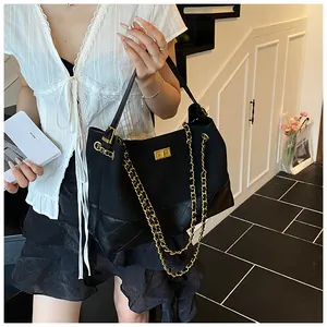 Dettaglio borsa shopper nera trapuntata con catena dorata e chiusura girevole chic