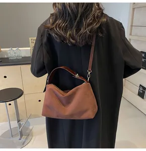 Détail du sac Boston marron foncé mat avec lanières en cuir sur fond minimaliste