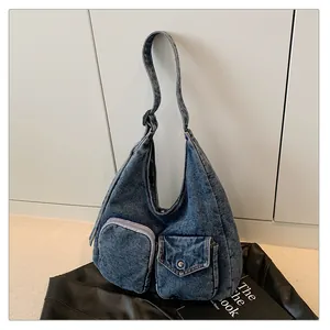 Vue détaillée du sac cabas en jean bleu foncé avec double poche frontale et texture lavée