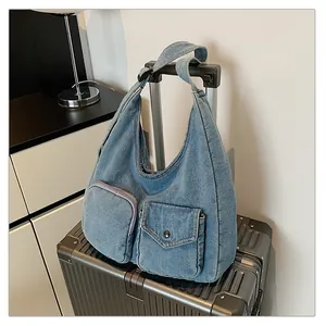 Détail du sac cabas en denim bleu délavé avec deux poches extérieures fonctionnelles