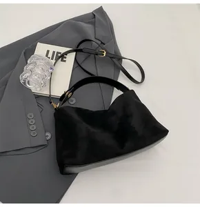 Détail du sac Boston noir montrant l'assemblage de suède, base en cuir et fermoirs dorés
