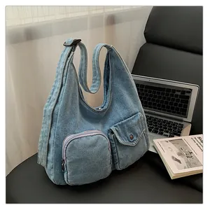 Détail du sac fourre-tout en jean bleu clair avec poches et fermetures éclair métalliques