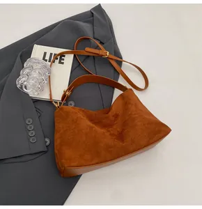 Détails de ce sac Boston en daim marron avec des coutures en cuir de haute qualité