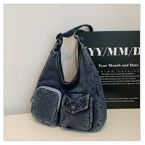 Détails du sac bandoulière en denim bleu foncé avec deux poches avant fonctionnelles