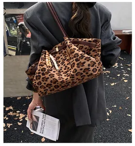 Detail einer Leopard-Tragetasche mit braunen Ledergriffen und Holzperlen-Anhänger