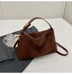 Détails du sac hobo en daim marron foncé avec ferrures dorées et fermoir pivotant chic