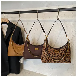 Détail des sacs hobo rétro avec imprimé léopard, cuir et accents de chaîne dorée