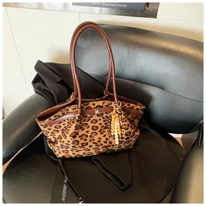 Detailaufnahme der Leo-Tasche mit Perlen-Quastenanhänger und braunen Ledergriffen