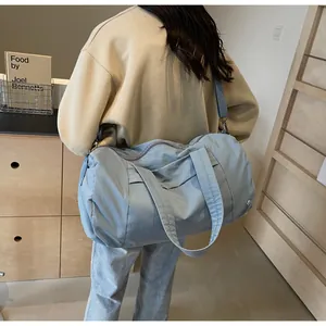 Grande borsa da viaggio in nylon grigio-blu con tracolla, indossata da una modella