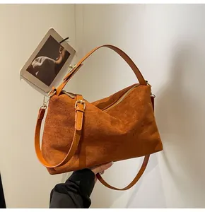 Détail du sac Boston en daim caramel montrant la texture douce et le zip doré chic