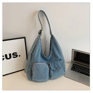 Détail du sac cabas en denim bleu avec poches extérieures et bandoulière réglable