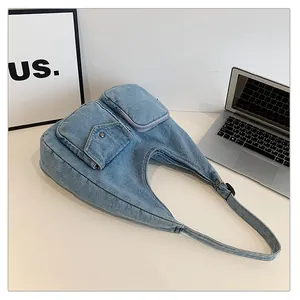Vue détaillée du sac cabas en denim bleu clair avec poches sur un bureau moderne