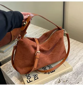 Vue détaillée du sac hobo en daim caramel avec bandoulière en cuir lisse et boucle dorée