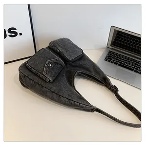 Détail du sac hobo en denim gris délavé avec poches cargo et boucle métallique rétro