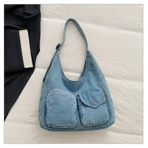 Détail du sac hobo en jean bleu clair avec poches cargo et texture délavée