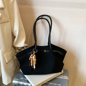 Minimalistische schwarze Cloud-Tasche mit Perlenanhänger auf silbernem Koffer im Set