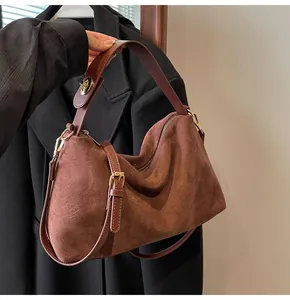 Détail du sac Boston en daim marron foncé mat avec bandoulière et ferrures dorées