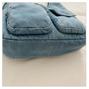 Détail du sac fourre-tout en denim montrant les poches avant et la texture du tissu