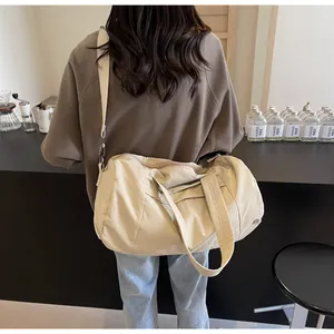 Borsa da viaggio beige in nylon impermeabile portata a spalla in un set lifestyle