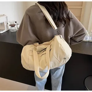 Dettaglio di una borsa da viaggio beige in nylon impermeabile con tracolla in un caffè