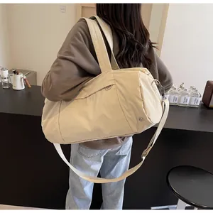 Dettaglio macro della borsa da viaggio in nylon impermeabile bianco crema con tracolla