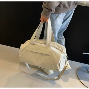 Dettaglio macro della borsa da viaggio in nylon impermeabile beige con tracolla regolabile