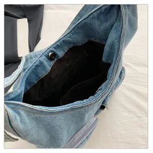 Vue détaillée de l'intérieur du sac en jean bleu avec fermeture aimantée et poche
