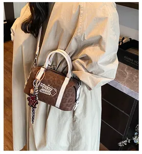 Chic leopard print Boston bag styled with a khaki trench coat and cute bear charm