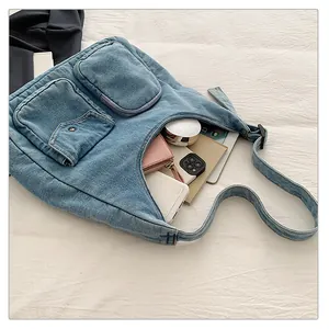 Détails du sac fourre-tout en denim bleu avec deux poches avant et texture souple