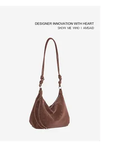 Macro detail of brown matte faux leather texture and knot decoration on hobo bag shoulder strap