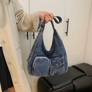 Sac hobo vintage en jean bleu avec deux poches avant et bandoulière réglable