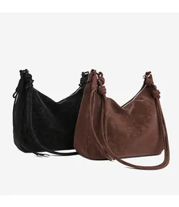 Detail of matte leather texture and knotted strap design on a minimalist shoulder bag