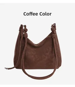 Detail of dark coffee suede tote bag showing knot strap and vintage leather texture