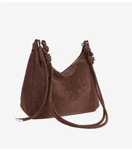 Close-up of decorative knot detail on deep brown suede vintage shoulder bag strap