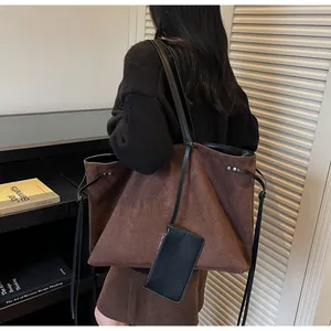 Vue détaillée du grand cabas en daim marron avec gaufrage TOTE BAG et bandoulière