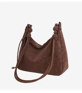 Close-up of the vintage knotted shoulder strap detail on a dark brown suede Hobo bag