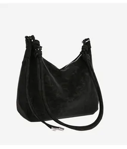 Detail of black suede tote bag showing knot strap and metallic silver hardware