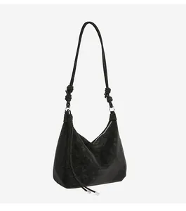 Detail of black faux suede hobo bag with knotted shoulder strap and silver hardware