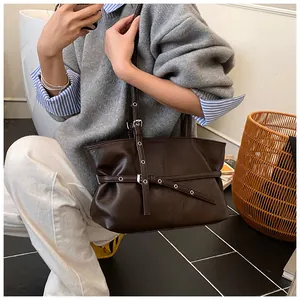 Détail du sac cabas marron foncé avec boucles de ceinture et texture en cuir lisse