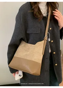 Minimalist retro tote bag featuring contrast suede and leather materials on a grey coat