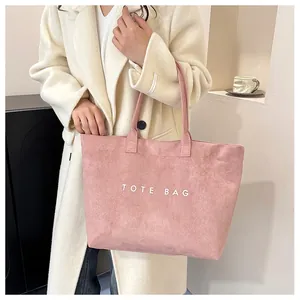 Pink suede tote bag styled with a beige coat for a trendy commuting look