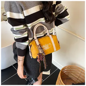 Detail of yellow boston bag with cartoon bear print, leopard charm and silk scarf wrap
