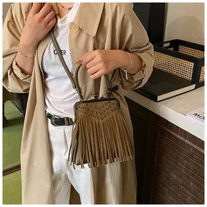 Detail of vintage fringe handbag with rivets and metallic clasp closure for crossbody use