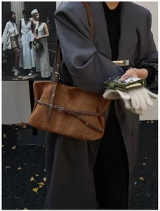 Détail d'un sac cabas en daim marron avec fine lanière de ceinture et boucle argentée