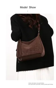 Macro shot of brown retro oil-waxed leather texture and silver buckle detail on hobo bag