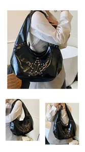 Detalle de bolso hobo negro brillante con remaches plateados en forma de estrella